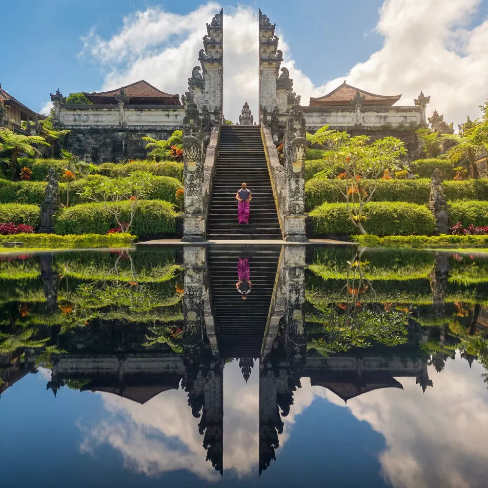 Temple stairway and gates mirrored in a still reflecting pool in Bali