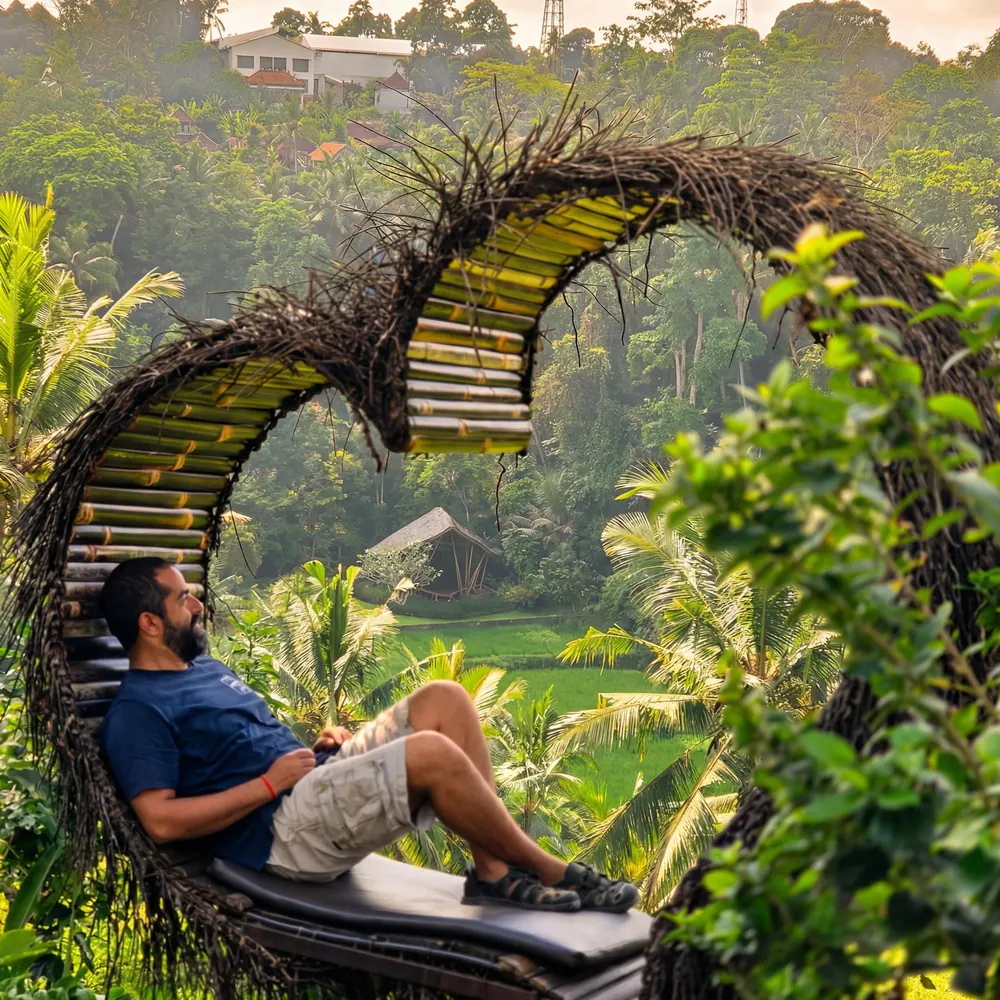 Man resting inside a woven heart-shaped arch in the jungle
