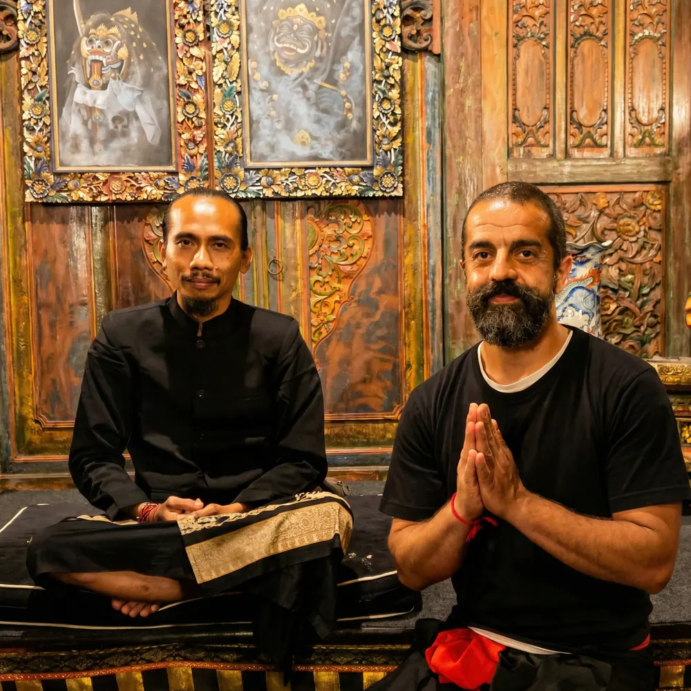 Two men seated before carved temple doors, one with palms together
