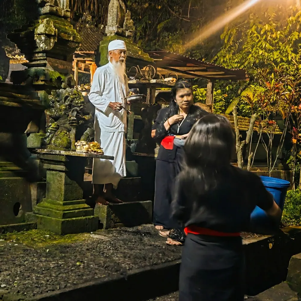 White-robed elder at an evening temple ceremony