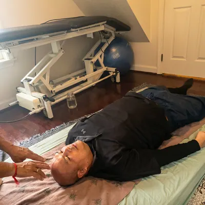 Man resting on a treatment table during energy work